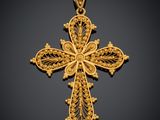 un pendentif en forme de croix dorée sur fond noir