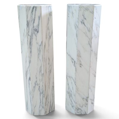 une paire de vases en marbre blanc posés sur une surface blanche, sur fond blanc