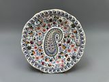 une assiette richement décorée, ornée d'un motif paisley