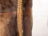 a brown fur vest on a mannequin stand