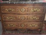 a wooden dresser with a marble top on a rug