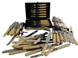 many different types of knives and forks in a case