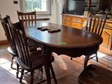 une table et des chaises en bois dans une cuisine dotée d'une fenêtre