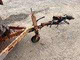 a rusted bike attached to a trailer in the dirt