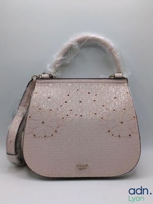 the small pink purse is sitting on a white surface