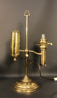 an antique brass table lamp with a glass bulb on top of it