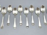six silver spoons are lined up in a row on a table
