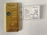 un gros plan sur un lingot d'or à côté d'une carte de visite