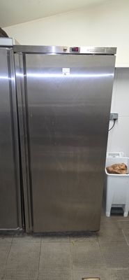 two stainless steel refrigerators in a kitchen next to a trash can