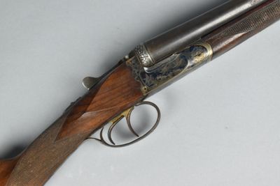 an old gun with a wooden handle on a white surface