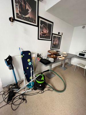 une pièce avec un bureau, un radiateur et des tableaux accrochés au mur