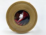 une image représentant une assiette en or sur laquelle figure une femme en robe rouge