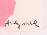 someone is writing on a piece of paper with a pink background