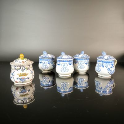 several blue and white teapots are lined up on a black table