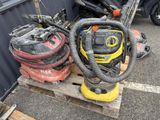 two vacuums on a pallet next to a pile of other equipment