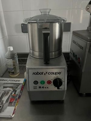un mixeur argenté posé sur le plan de travail d'une cuisine