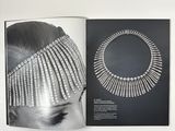 an open book with a black and white photo of a woman wearing a headpiece