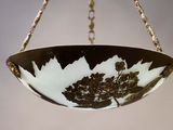 a black and white bowl hanging from a gold chain