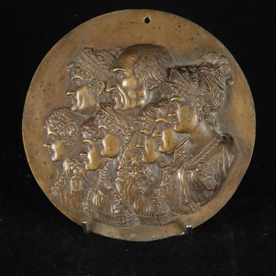 an antique bronze plaque depicting a group of women and a man