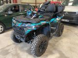 a blue and black atv parked in a garage next to other vehicles