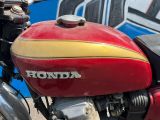 une moto rouge et jaune garée devant un mur bleu et blanc