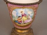 a vase with a painting on it sitting on a stand