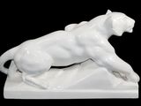 a figurine of a cat that is laying on the ground