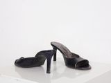 pair of black high heeled shoes sitting on a white surface