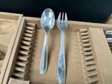 two silver spoons and a fork in a box
