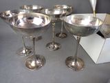 six silver wine glasses sitting on top of a table next to a box