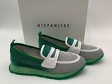 une paire de chaussures vertes et blanches avec une boîte en arrière-plan