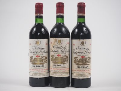 trois bouteilles de vin rouge posées l'une à côté de l'autre sur une surface blanche