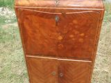 une vieille commode en bois posée dans un champ d'herbe