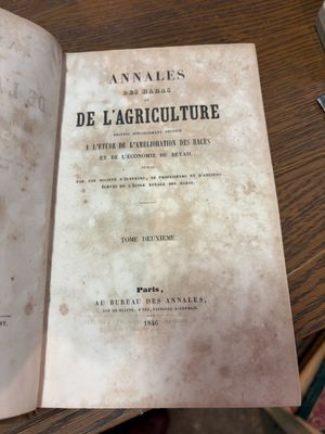 un vieux livre posé sur une table, à côté d'un stylo et d'une tasse de café