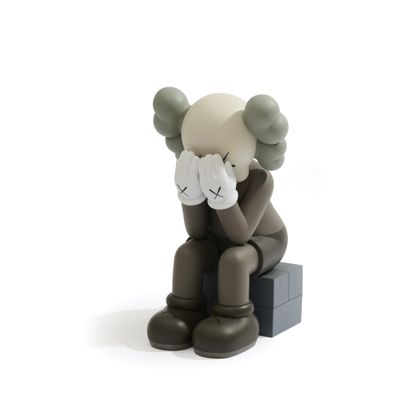une figurine représentant un ours en peluche assis sur une boîte
