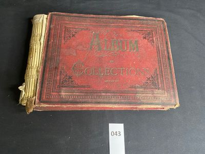 an old book with a red cover sitting on top of a table