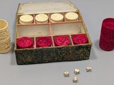 a box of dice and a cup next to it on a table