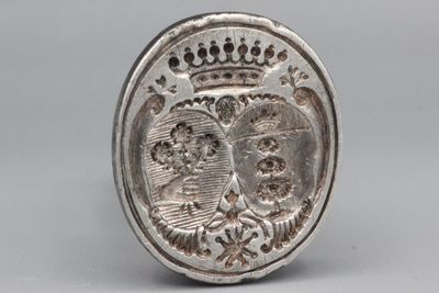 Cachet en métal gravé d’armoiries surmontées d’une couronne.