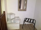 a picture of a hallway with a chair and a mirror