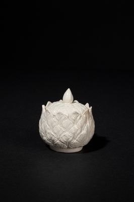 a white vase that is sitting on a black surface