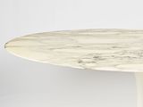 an oval marble dining table with a white base