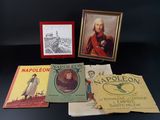 Plusieurs livres sont posés sur une table, à côté d'un cadre photo.