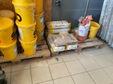 many yellow buckets sitting on a pallet in a room
