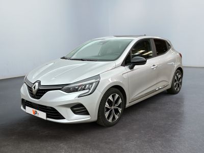 Une voiture blanche est garée dans une pièce au sol noir.