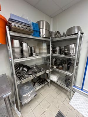 de nombreuses casseroles et poêles sur les étagères de la cuisine