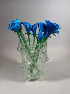 a vase with blue flowers in it on a white surface