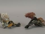 two figurines of a man and a woman sitting on a branch