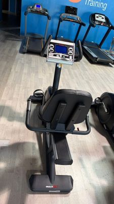a gym room with tread machines and a monitor on the wall