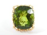 un gros plan d'une bague ornée d'une pierre verte sur un fond blanc