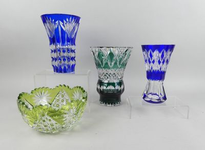 quatre vases en verre de couleurs différentes posés sur une surface blanche